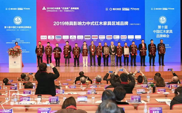 全联民间文物艺术品商会会长助理肖秉侠（右七）、深圳大学家具设计研究所所长唐开军（左七）为“2019特具影响力中式红木家具区域品牌”获奖者颁奖，分别为安徽中皖泰森红木、云南林达宏红木家居、山东大户人家红木、福建海龙红木艺术馆、广东中联红木世家（华木苑）、河南雍庭红木、广西中港红木文化馆、辽宁中海家居红木馆、湖南福居阁艺术红木馆、内蒙古尚古堂红木艺术收藏馆、河北常记家居、河北大家风范红木楼、新疆佳宝阁红木馆、江苏陶都红木