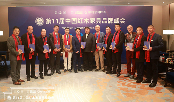 故宫学院院长单霁翔向红木家具企业代表赠书并合影，传递匠心精神